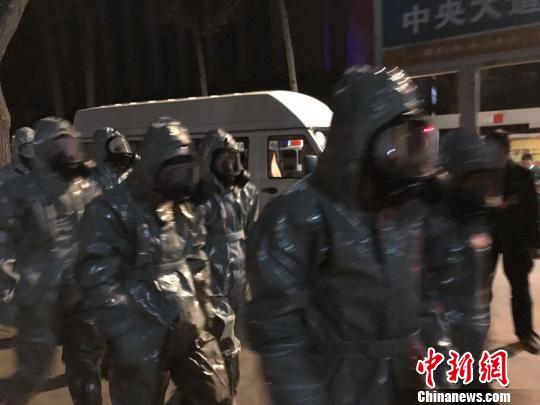 十几名身着防护服的人员头戴面具进入事发地。　胡健 摄